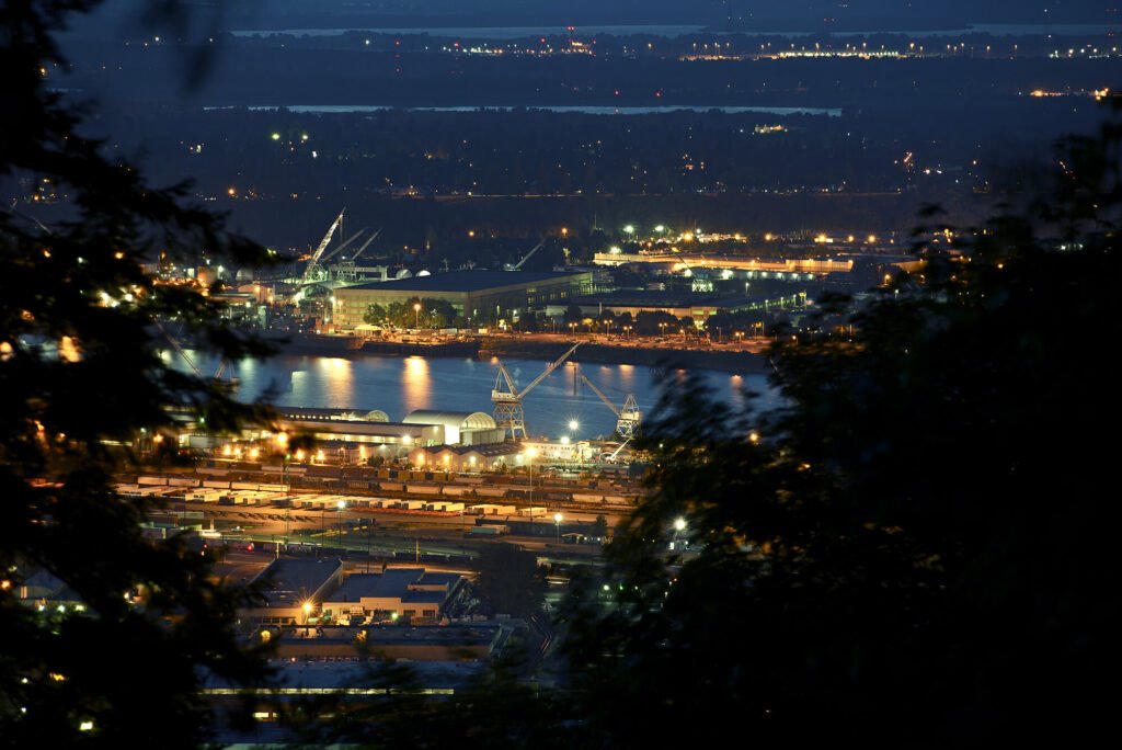 An industrial port and rail yard lit up at night
